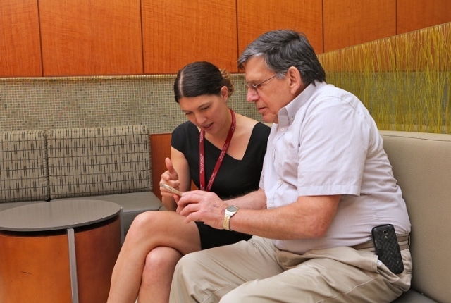 Dr. Heather Yeo shows patient David Matthews the mHeals app