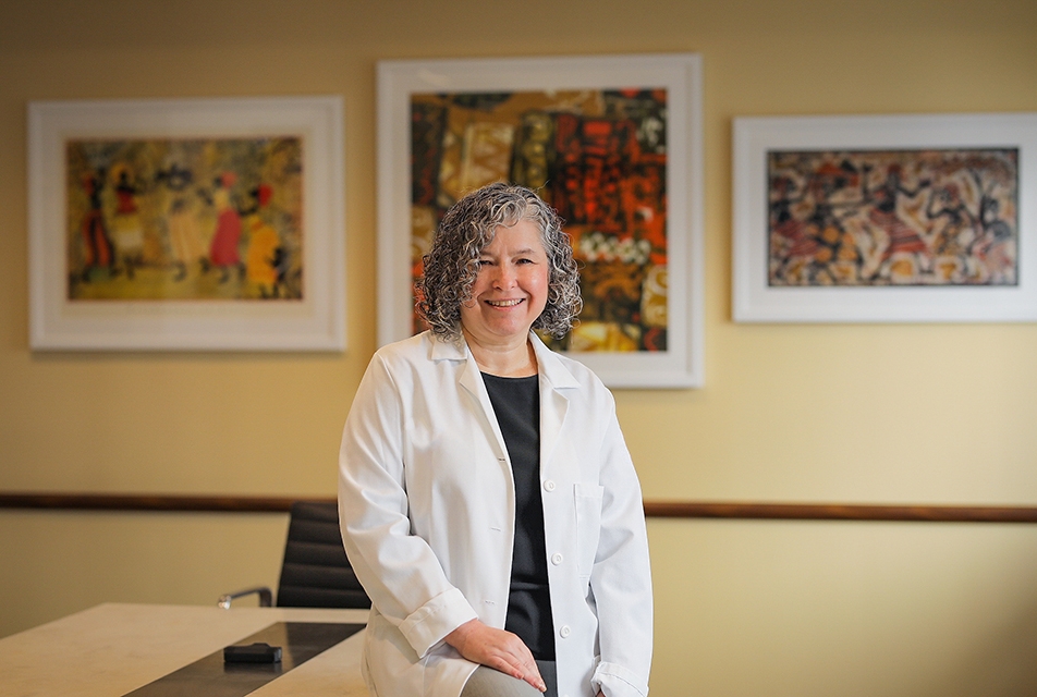 a woman in a white coat posing for a photo