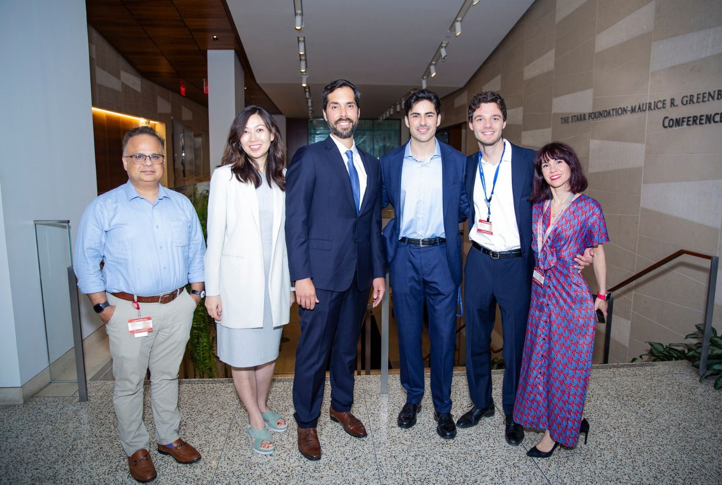 Six people (four men and two women) wearing business attire in a group photo