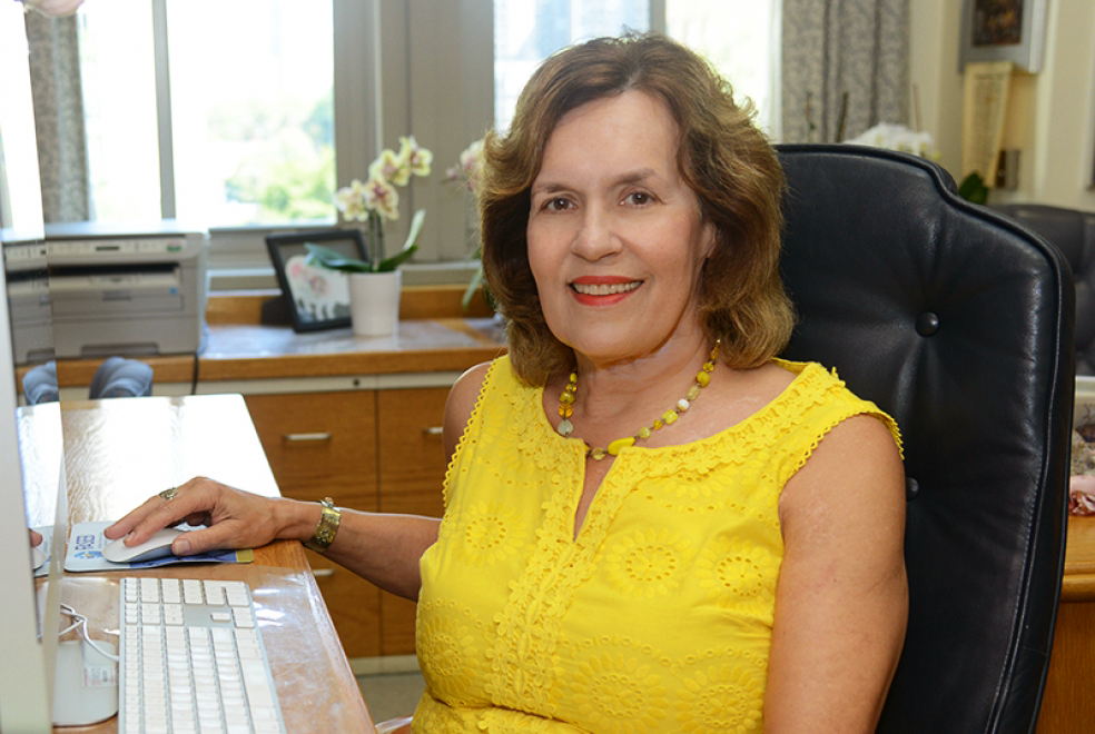 a woman sitting at a desk smiling