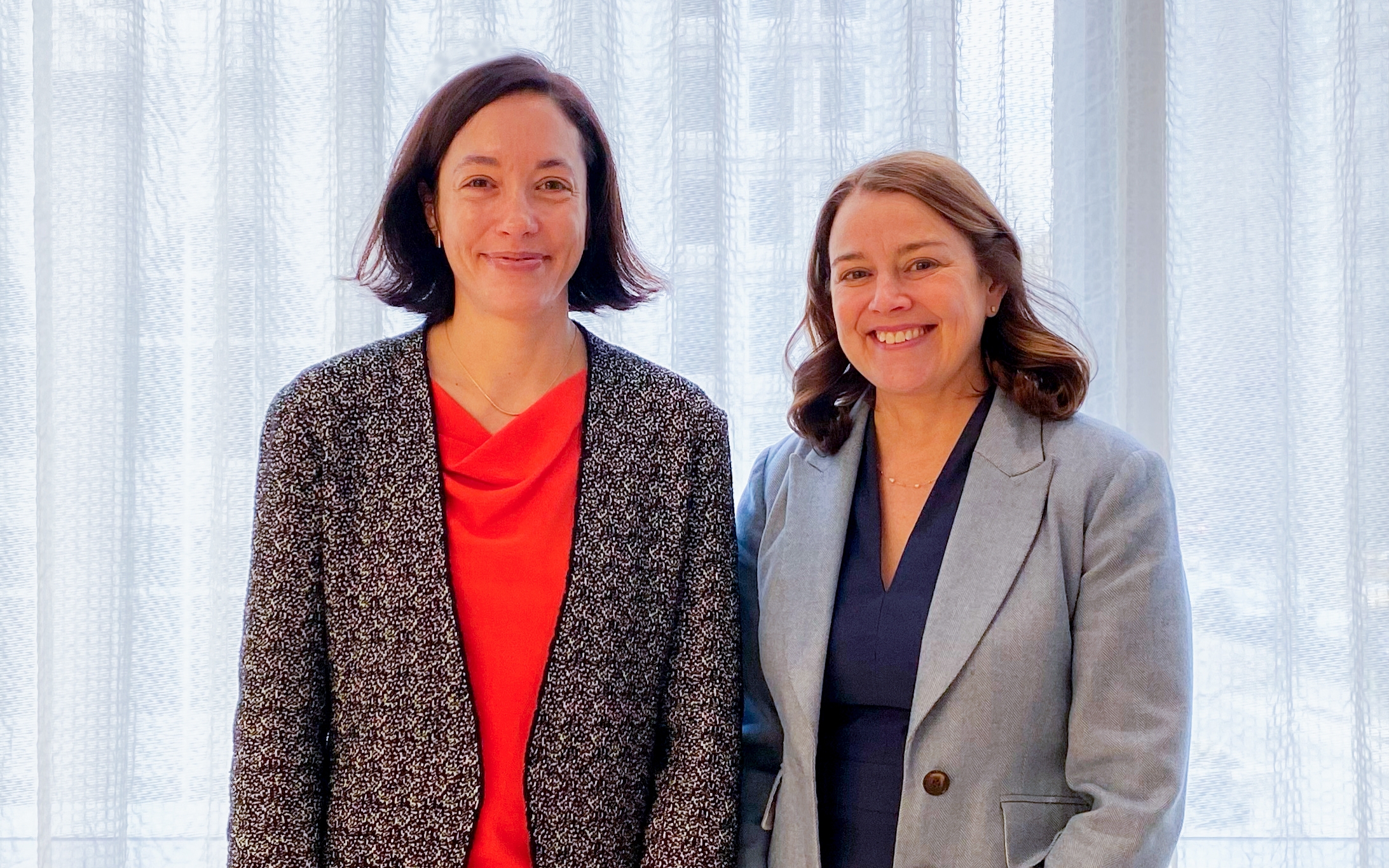 Two women standing next to each other in a room