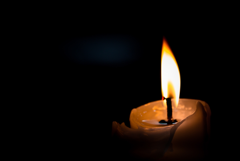 photo of a candle burning in the dark