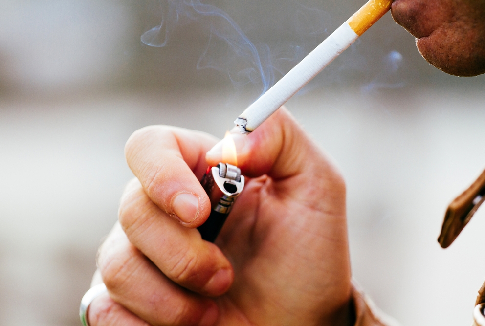 A person lighting a cigarette