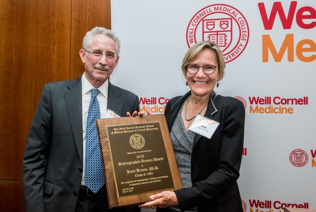 Dr. Janet Braam holding her award plaque and posing with Dr. Carl Nathan