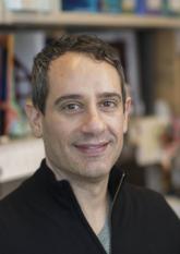 a man in a lab coat smiling for a picture