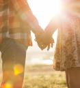 image of man and woman holding hands in the sunlight